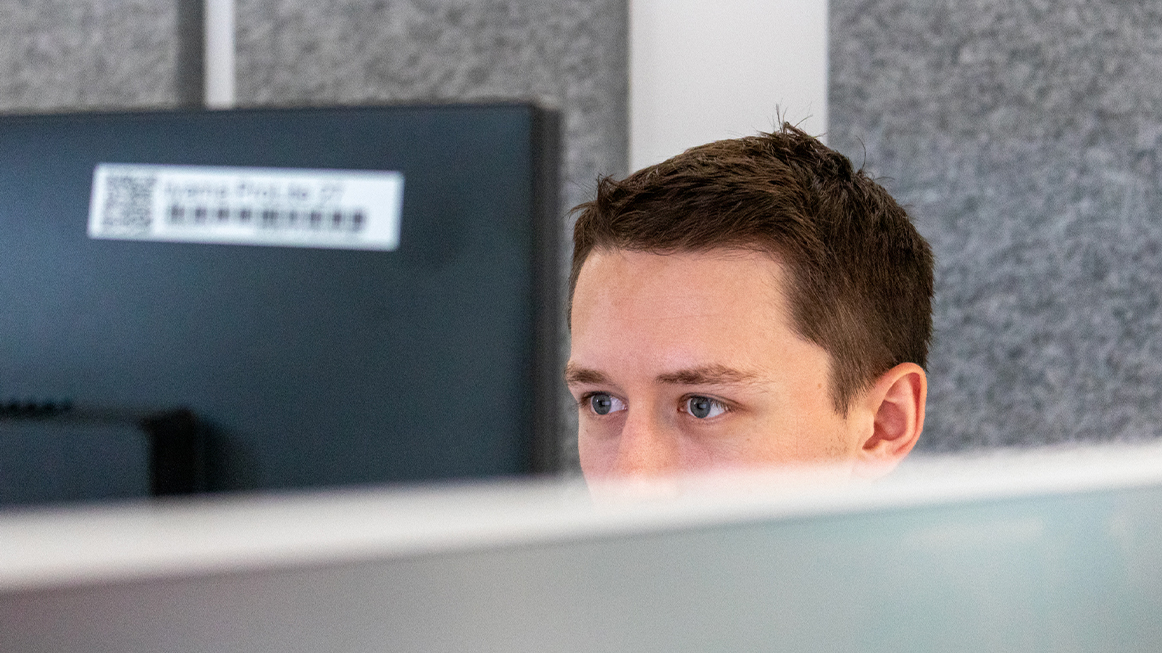 person with short brown hair working in multi desk space (Photo)