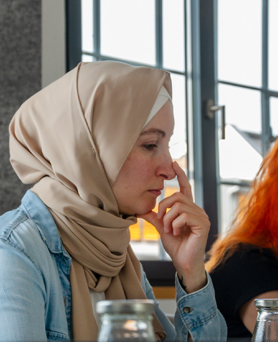 person in a head scarf thinking in a meeting (Photo)