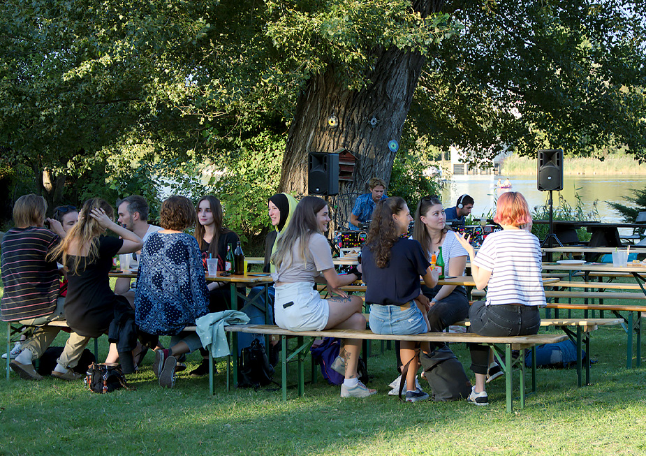 groups of people sitting on beer benches outside at the nexxar summer fest (Photo)