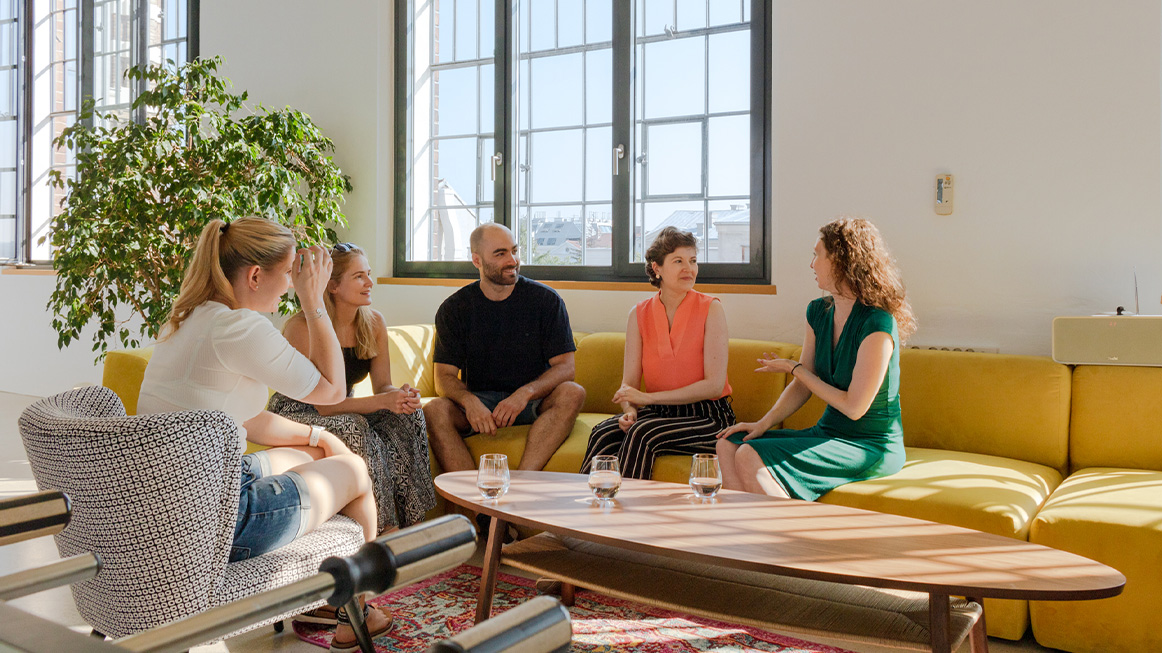 several people chatting over drinks on the large yellow sofa (Photo)