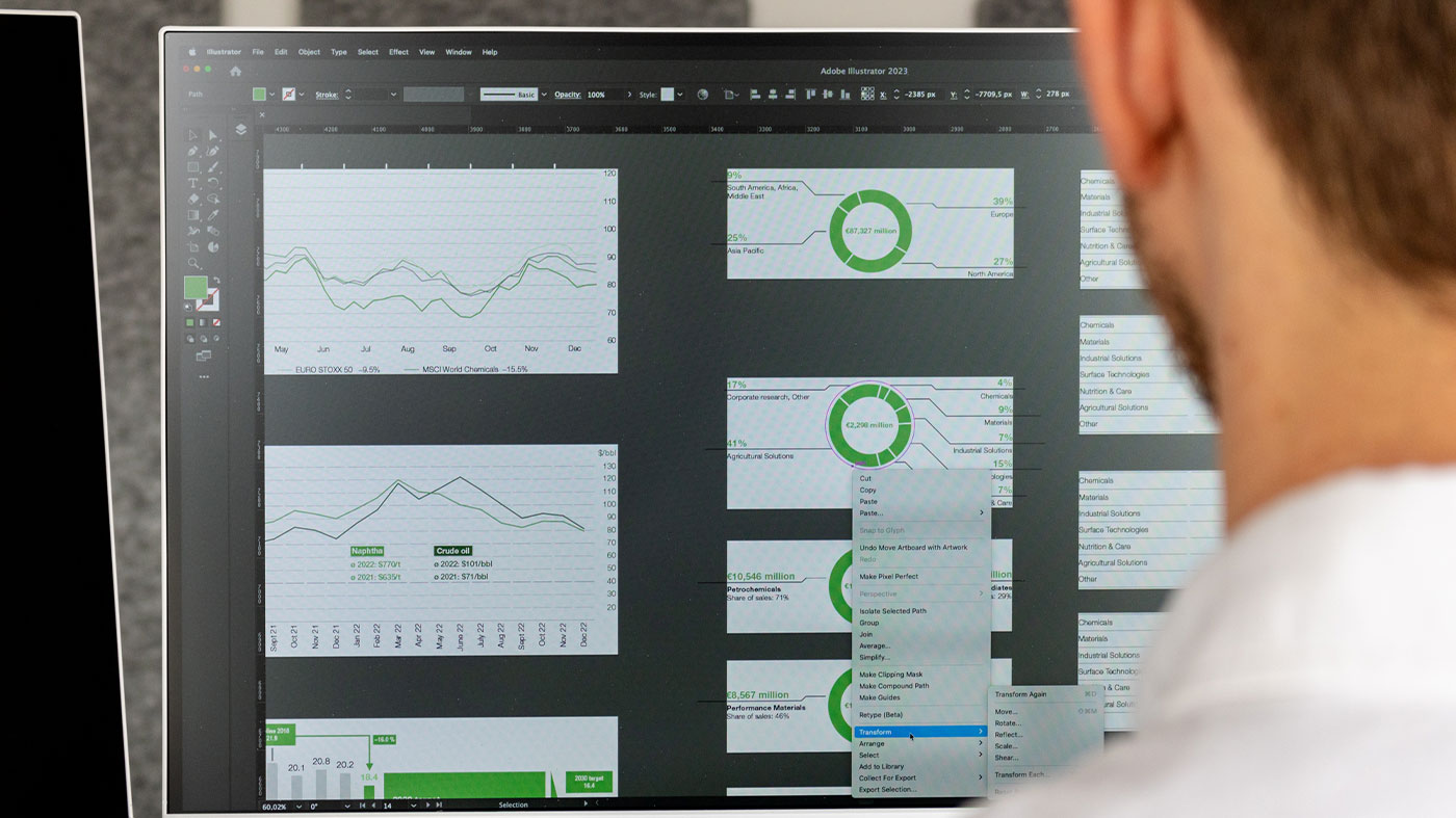 looking over a designers shoulder as they finalize graphics showing graphs (Photo)